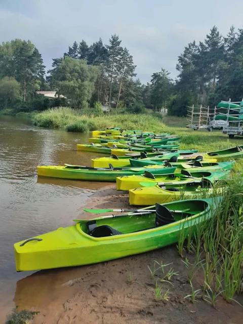 Zielono-żółte kajaki przygotowane na brzegu