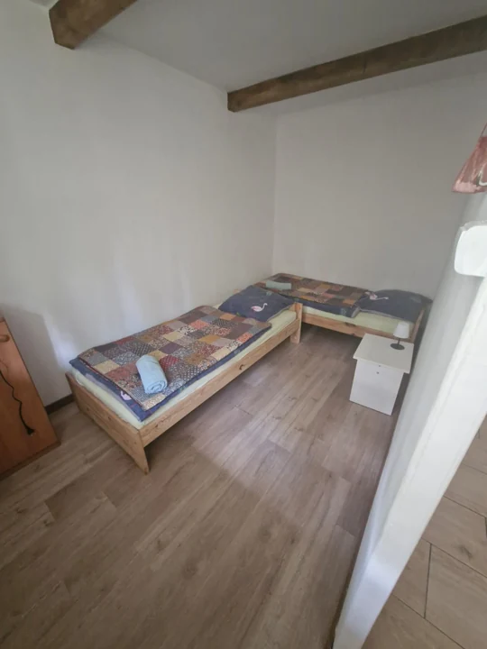Sypialnia z podwójnym łóżkiem i drewnianymi belkami
