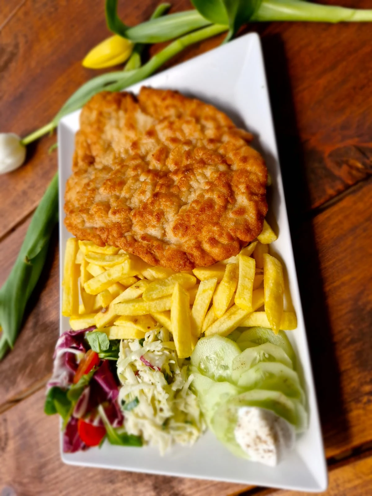 Panierowany kotlet z frytkami i surówkami